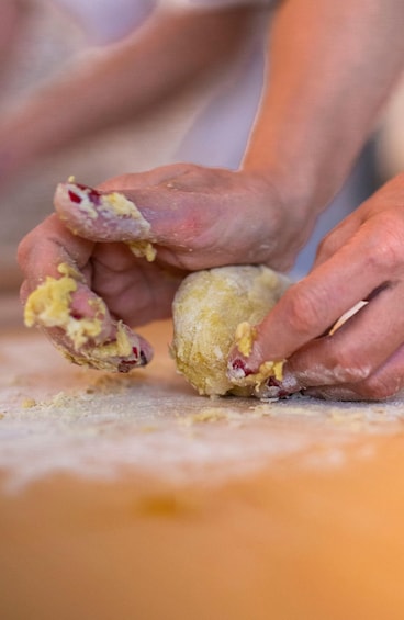 Hands shaping dough on a surface. 5