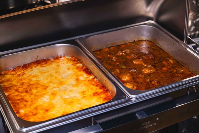A buffet with two dishes: a baked casserole and a stew. 2