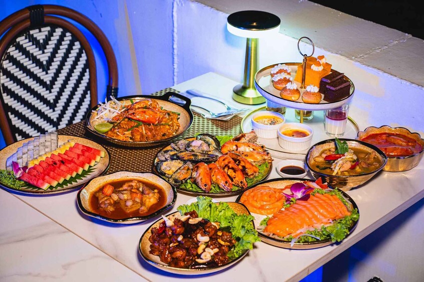 A table with various seafood dishes, including shrimp, lobster, and salmon, along with some desserts and side dishes. 4
