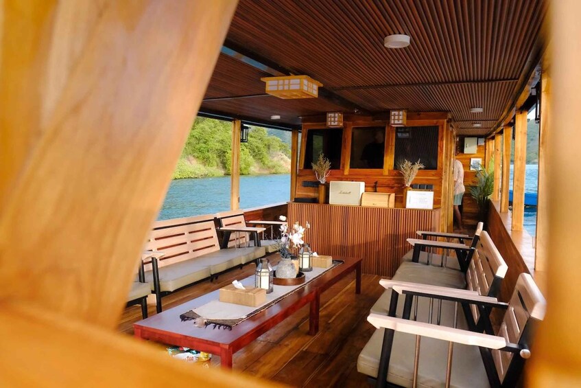 A wooden deck with seating and tables overlooking a body of water. 5