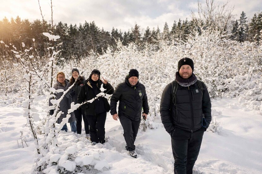 A group of people walking through a snowy forest. 1