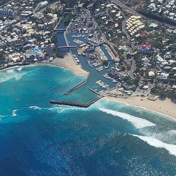 An aerial view of a coastal town with a marina, a pier, and a beach. 5