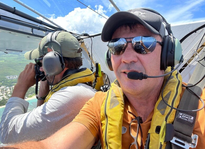 Two individuals in a cockpit, one wearing a headset and the other with a microphone. 3