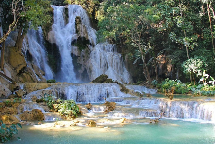 A multi-tiered waterfall surrounded by lush greenery. 1