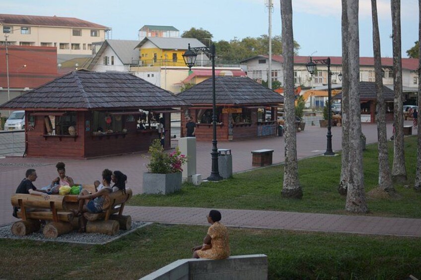 A park with wooden benches, a playground, and a café. 5