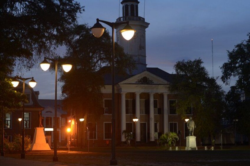 A building with columns and a clock tower at dusk. 2