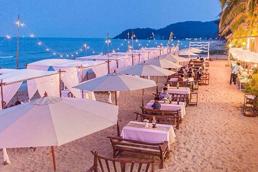 A beachside restaurant with white umbrellas and tables. 3
