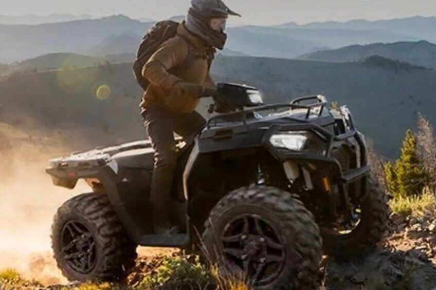Una persona conduciendo un cuatrimoto por un sendero de montaña. 1