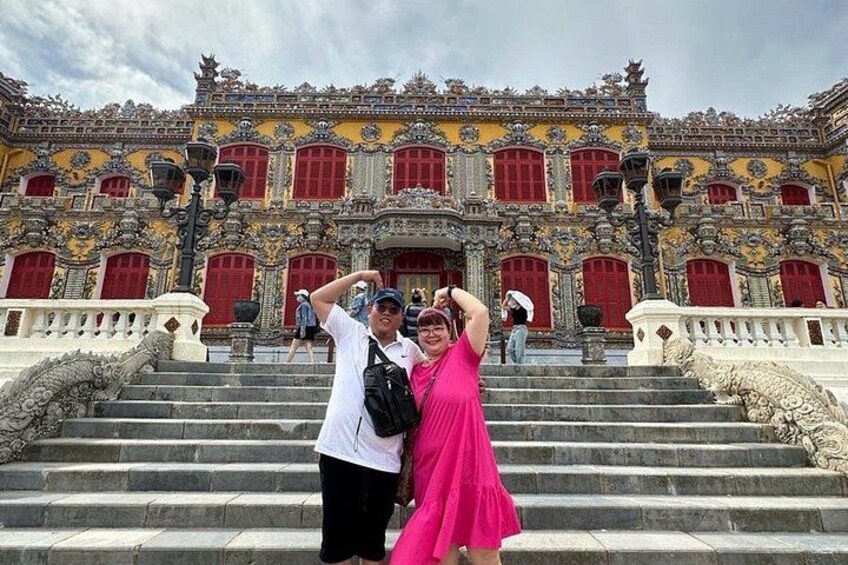 A grand building with ornate architecture, a staircase, and a person in a pink dress. 5