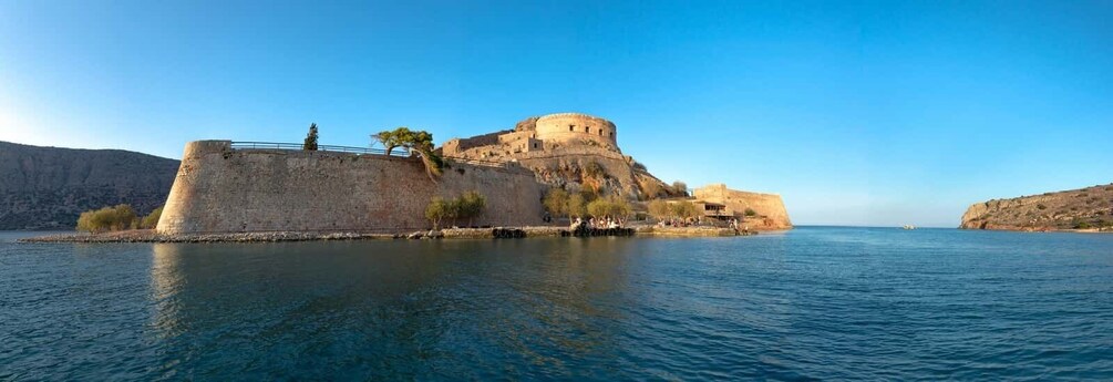 A historic fortification by a calm sea, with clear skies. 3