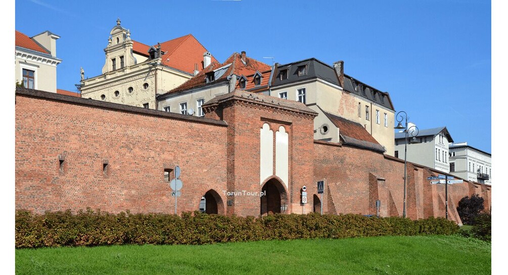 A historic brick building with arched windows and a tower. 4