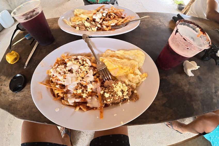A table with two plates of food, a drink, and a fork. 3