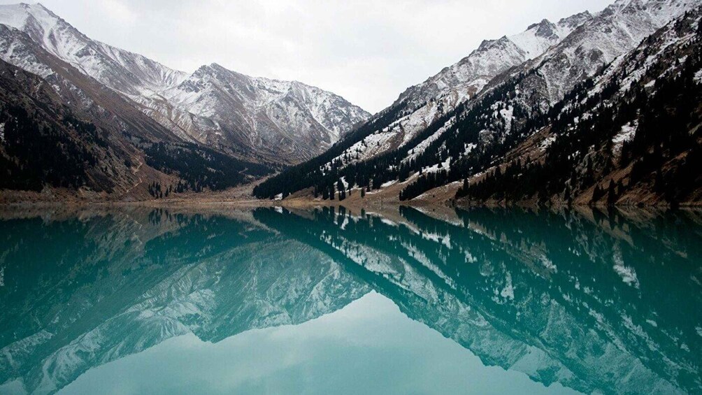 A mountain lake with snow-capped peaks and clear reflections. 5