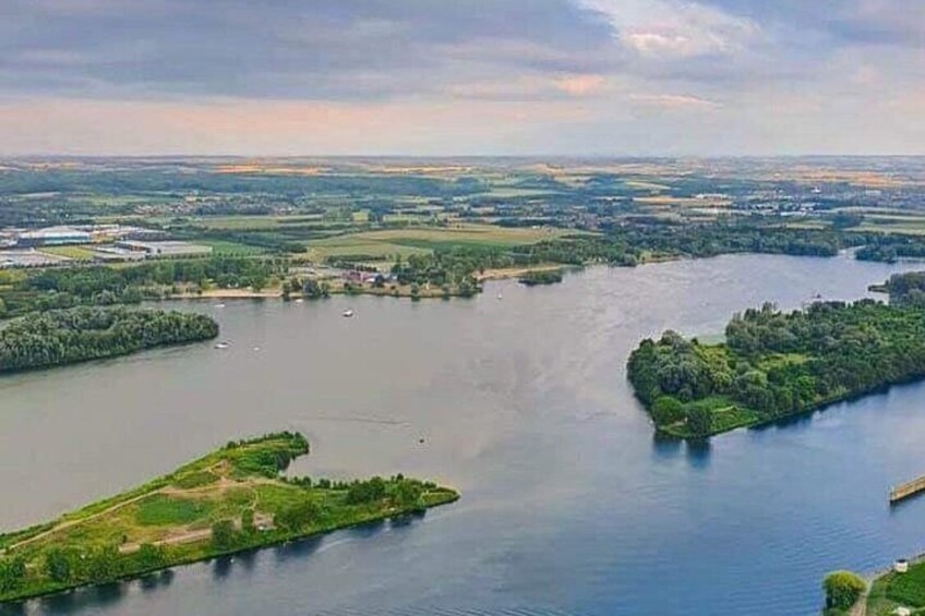 A river with islands, a distant cityscape, and a cloudy sky. 5