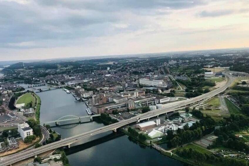 An aerial view of a city with a river, bridges, and surrounding greenery. 4