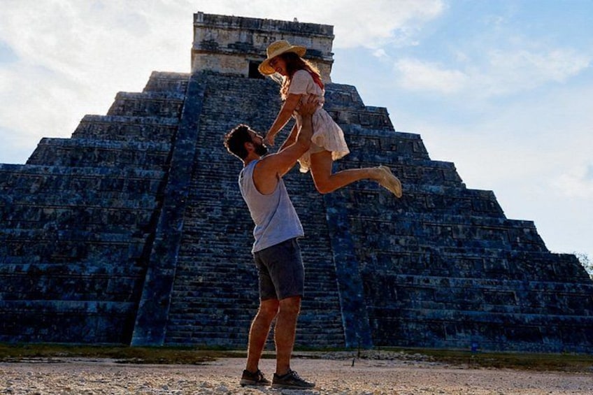 A person lifting another person in front of a large pyramid. 1