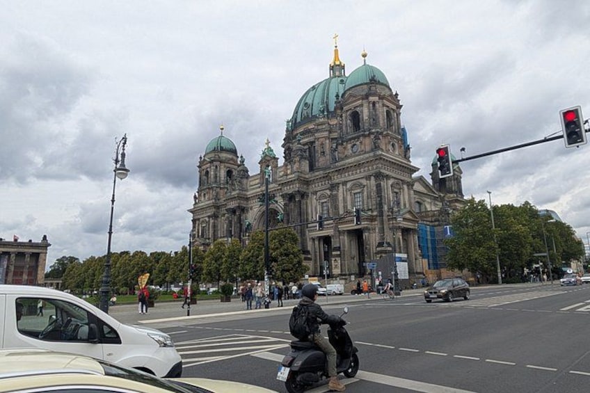 A large historic building with domes and a traffic light. 2