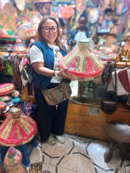 A person holding a colorful woven basket in a market. 3
