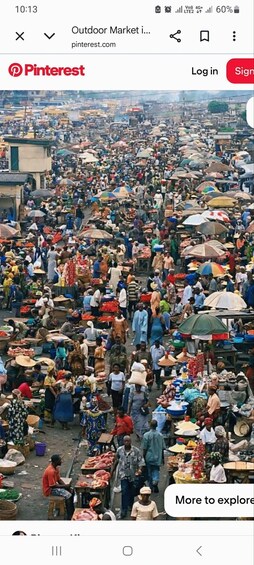 A crowded outdoor market with numerous stalls and people. 4