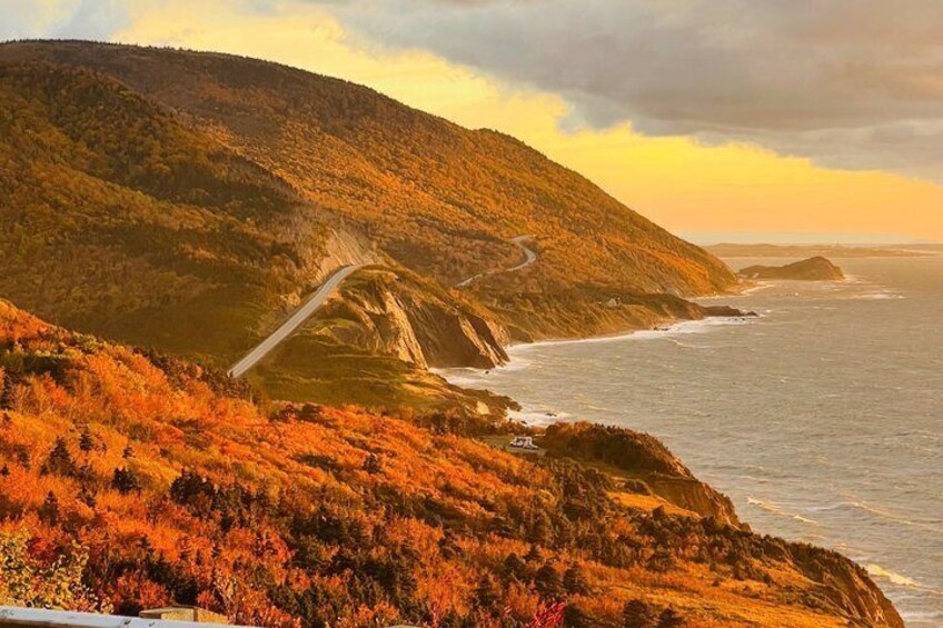 A coastal road winding through a hilly landscape with autumn foliage. 1