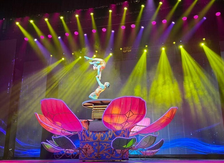 A circus performer balancing on a platform with vibrant, illuminated lotus petals. 5