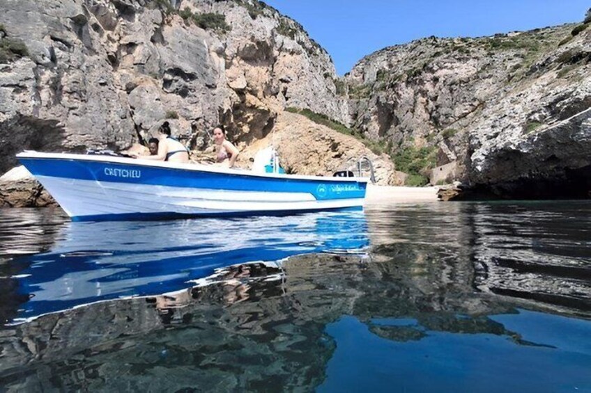 Ein Boot namens 'Crestone' auf ruhigem Wasser, im Hintergrund felsige Klippen. 2