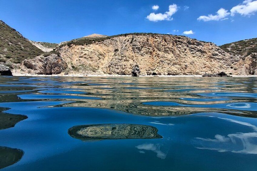 A lake with clear blue water, surrounded by rocky hills. 2