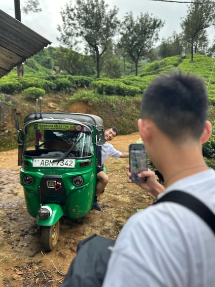 A green auto-rickshaw parked on a dirt path with a person sitting in the front. 5