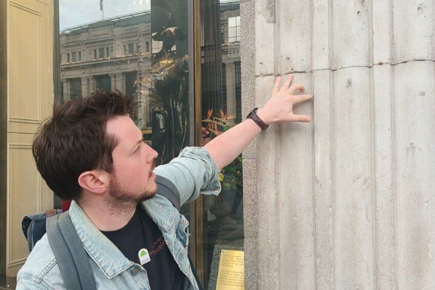 A person leaning against a concrete column. 2