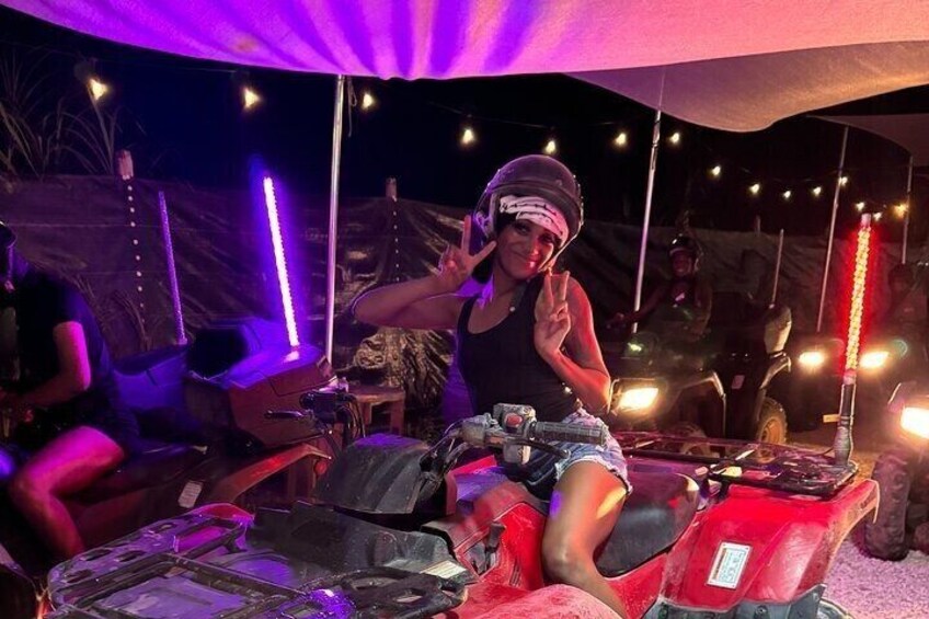 Una persona en un ATV rojo bajo una carpa con luces de cuerda. 3
