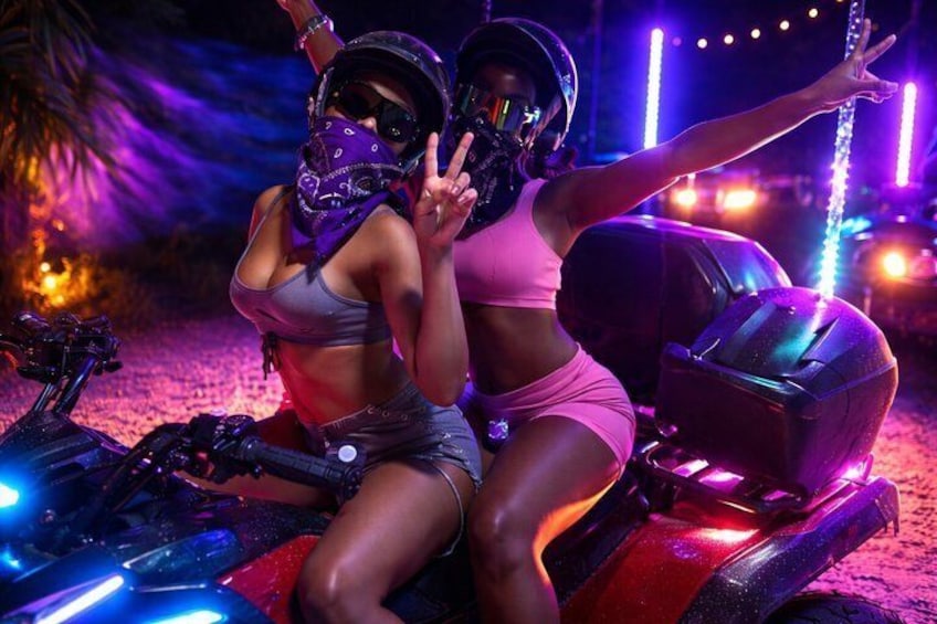 Twee personen op een motorfiets met neonverlichting, in een nachtelijke setting. 5