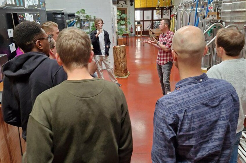 En grupp människor i ett rum med industriell utrustning och ett polerat golv. 2