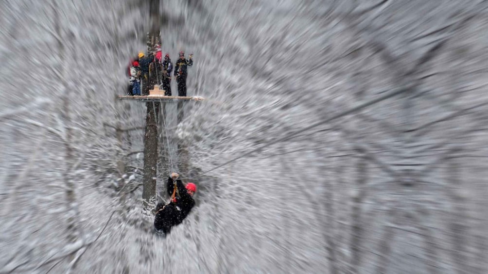 A group of people on a platform in a snowy environment, possibly engaged in a winter sport or activity. 2