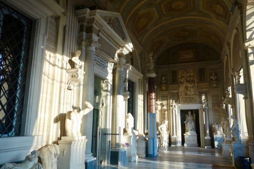 Een statige zaal met klassieke architectuur, met kolommen, beelden en ingewikkelde plafonddecoraties. 4
