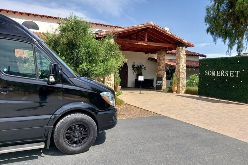 A black van parked in front of a building with a sign that reads 'SOMERSET.' 5