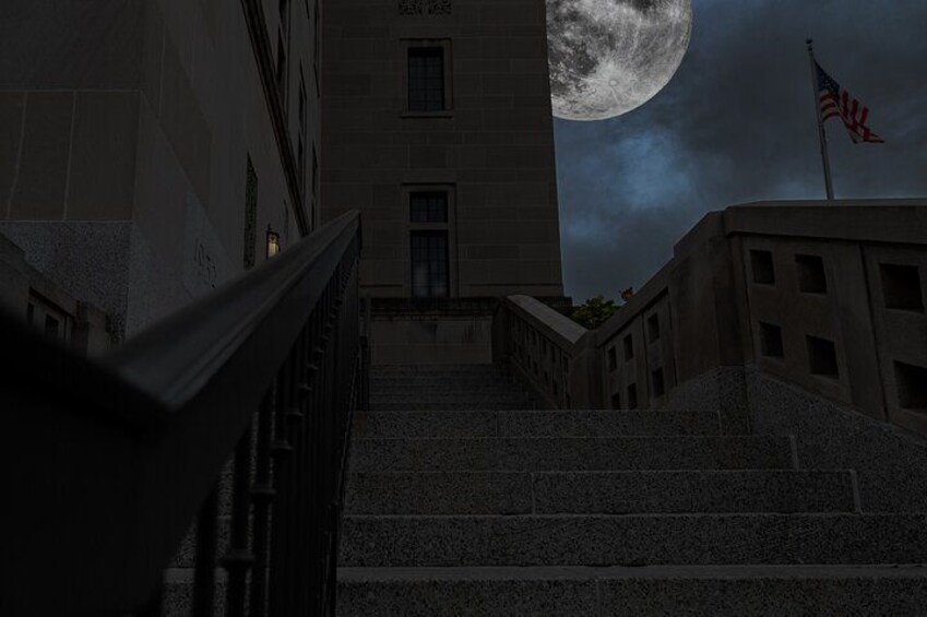 Un edificio con una luna grande al fondo, una escalera y una bandera estadounidense. 2