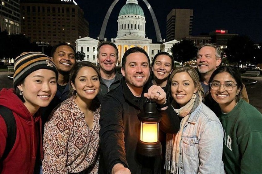 Un grupo de personas posando frente a un edificio grande con una cúpula y una entrada curva. 4