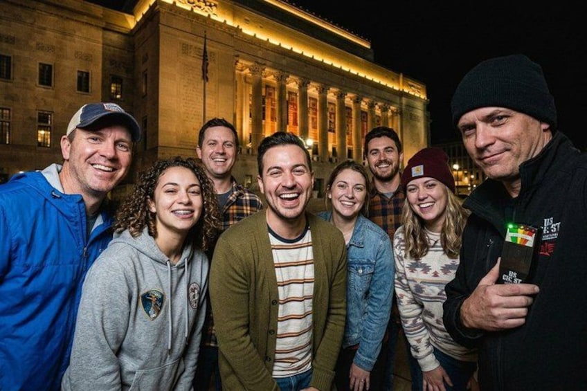 Un grupo de personas de pie frente a un edificio de arquitectura clásica. 2
