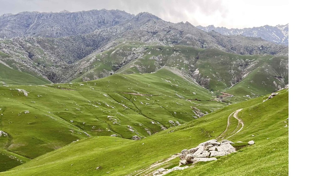 A mountainous landscape with green valleys and rocky outcrops. 2