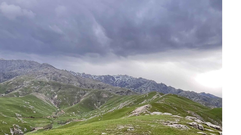 A mountainous landscape with green valleys and a cloudy sky. 3