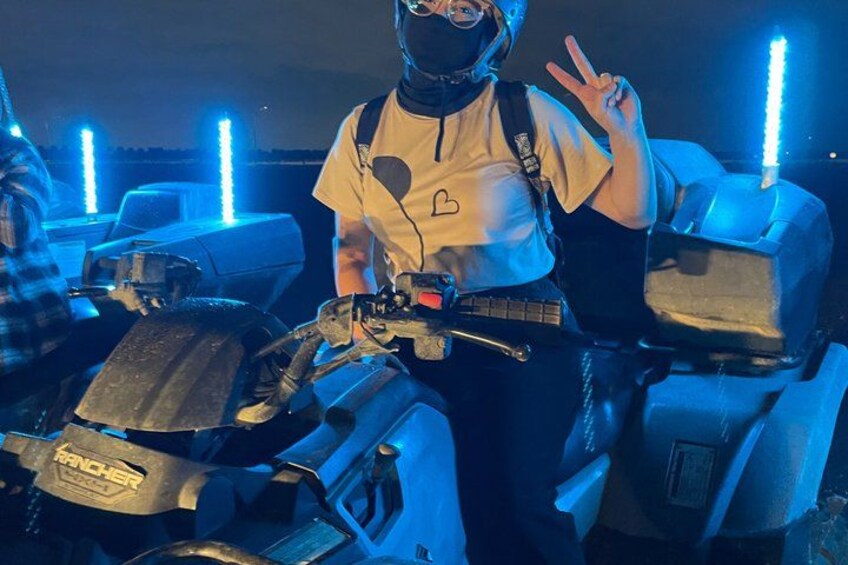 A person on a quad bike with a heart symbol on their shirt, surrounded by quad bikes with blue lights. 2