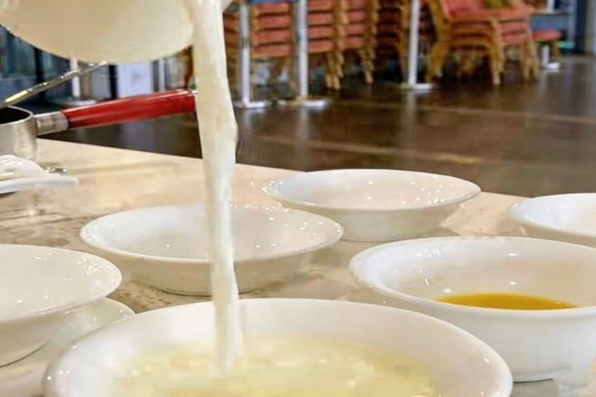 A milk jug pouring milk into bowls. 2