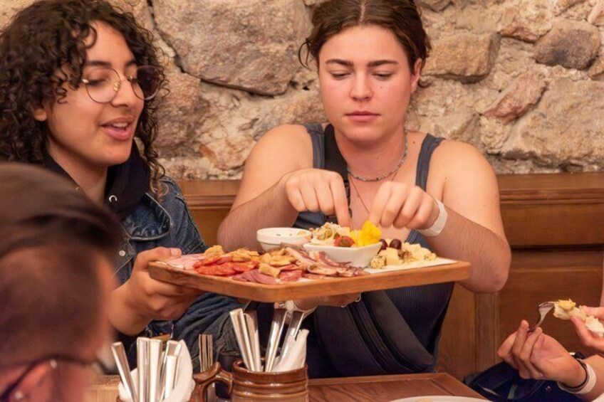 To personer spiser middag på en restaurant med en murstensvæg i baggrunden. 5