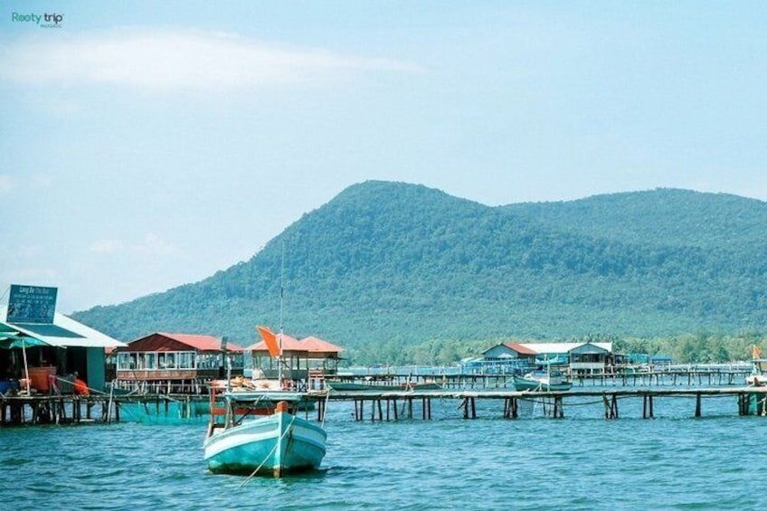 A boat on water, a pier, and a mountain in the background. 3