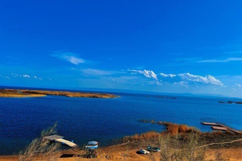 Un paysage côtier avec un ciel dégagé, une mer calme et un petit quai. 5