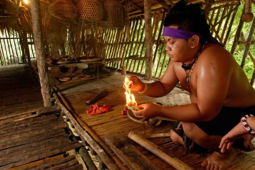 A person performing a ritual with a fire in a wooden hut. 3