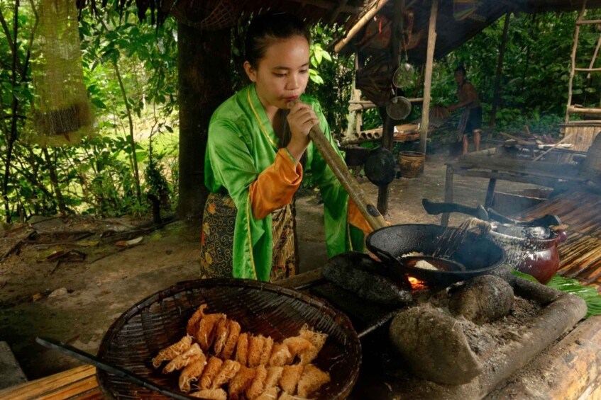 A person cooking outdoors with a grill and a pot over an open fire. 4