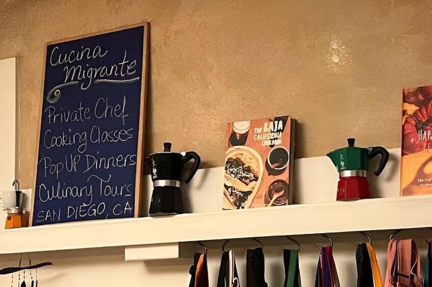 A chalkboard menu listing services like private chef and cooking classes, coffee machines, and books on the shelf. 2