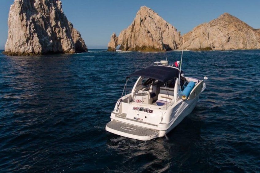 A boat on calm water with rocky formations in the background. 1