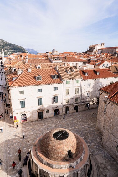 A historic square with a central dome, red-tiled buildings, and a clear sky. 4